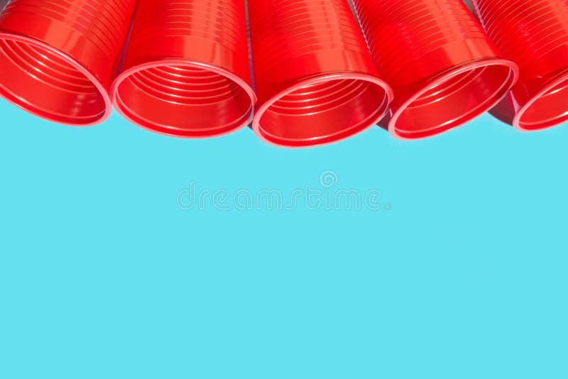 Row of red plastic drinking cup on blue background. Environmental protection plastic-free alternatives nature friendly living stock photos Row of red plastic drinking cup on blue background. Environmental protection plastic-free alternatives nature friendly living stock photos