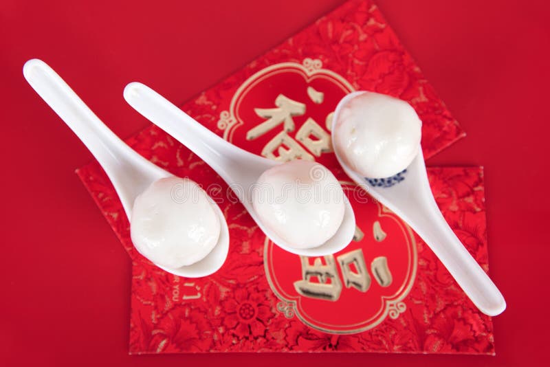 A row of spoons with dumplings on the red envelope. The Chinese characters in the picture mean `happiness` royalty free stock photo