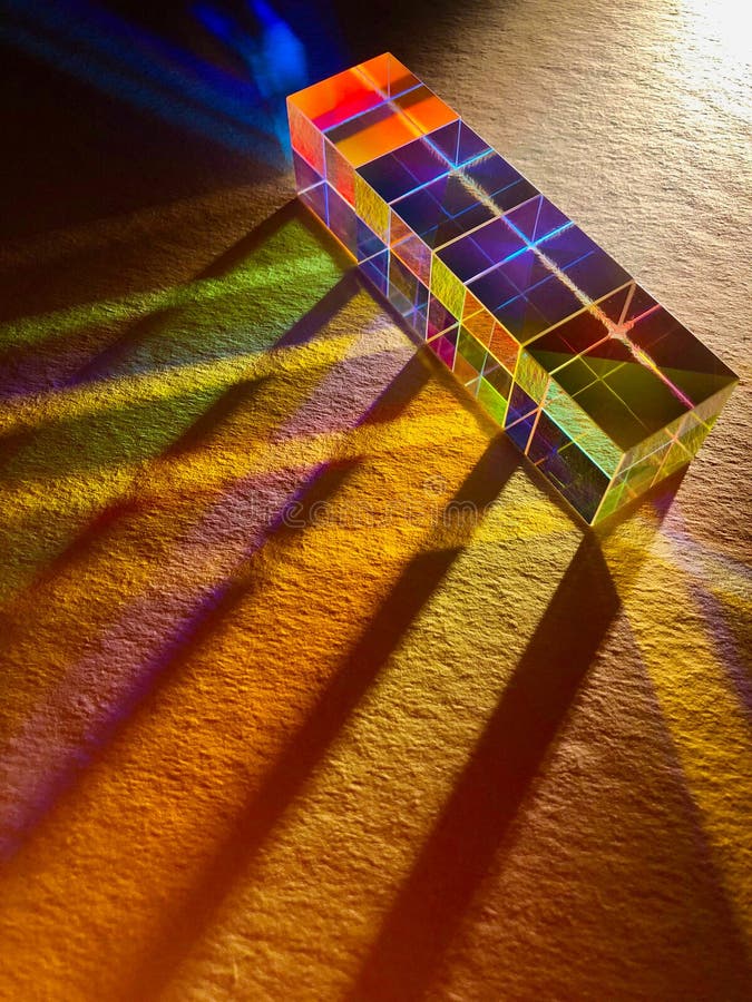 A row of square dichroic glass cubes spreading beam of light into many color spectrums. A row of square dichroic glass cubes diffusing beam of light into many