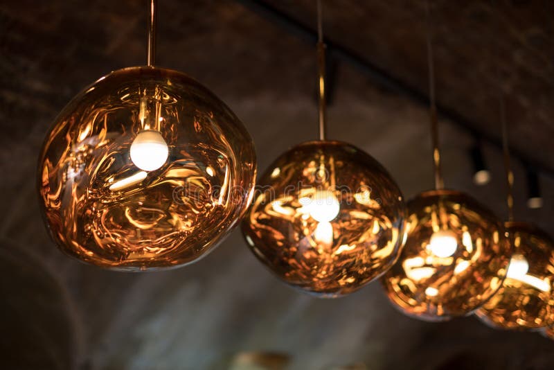 Row of Tom Dixon metallic pendant lights hanging in the Tom Dixon flagship store and showroom at Coal Drops Yard, Kings Cross.