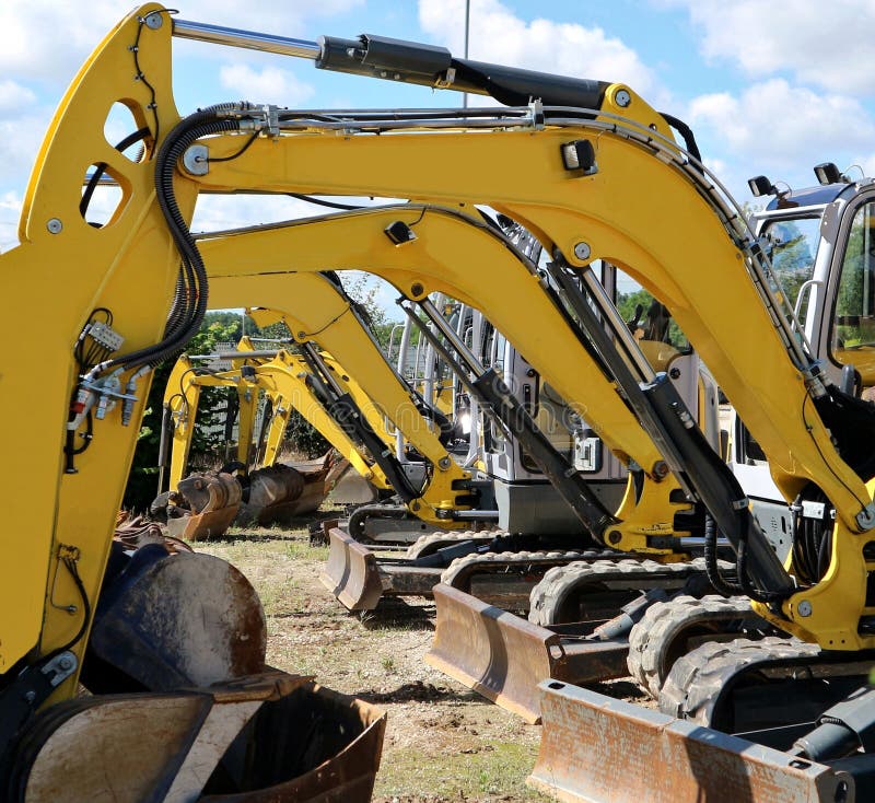 Row of yellow booms and buckets of mini excavators.