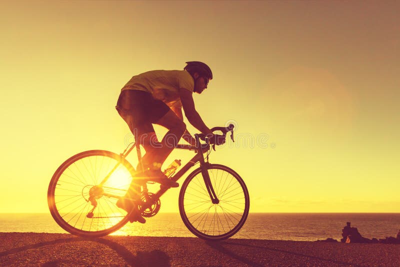 Rowerzysta drogowy człowiek jeździ na rowerze w zachodzie słońca