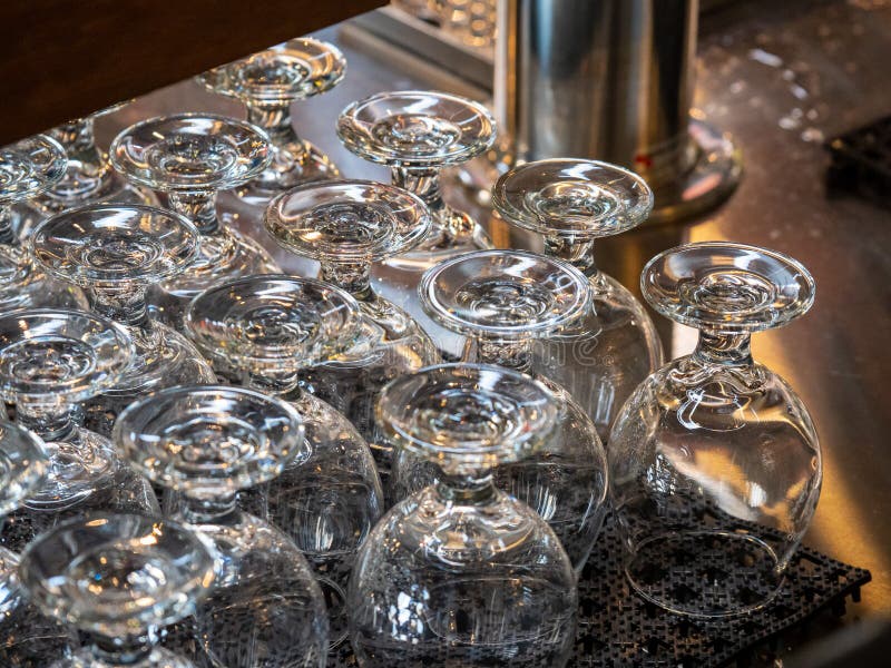 Rows of Beer Snifters Glasses Resting on Bar Ready for Serving Stock