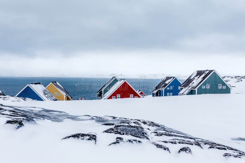 Rows of colorful inuit houses among rocks in a suburb of arctic