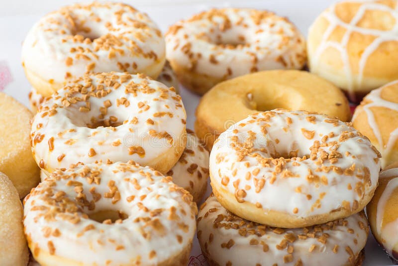 Rows Piles of Various Kinds of Artisanal Home Baked Donuts Glazed with Caramel Sprinkles at Farmers Market. Yeast Sweet Pastry. royalty free stock photo Rows Piles of Various Kinds of Artisanal Home Baked Donuts Glazed with Caramel Sprinkles at Farmers Market. Yeast Sweet Pastry. royalty free stock photo