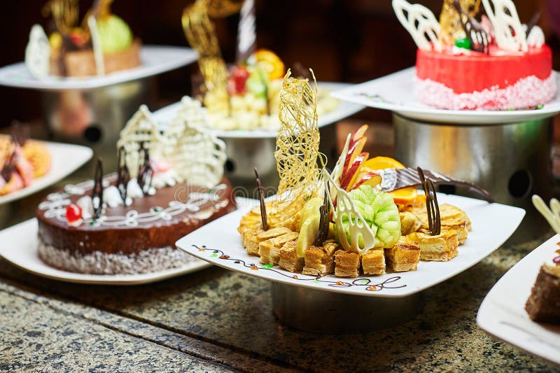 Rows of tasty looking desserts in beautiful arrangements. Sweets on banquet table - picture taken during catering event. Decorated, buffet.