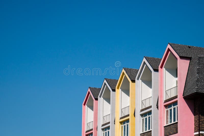 Colorful pink and yellow house against blue sky