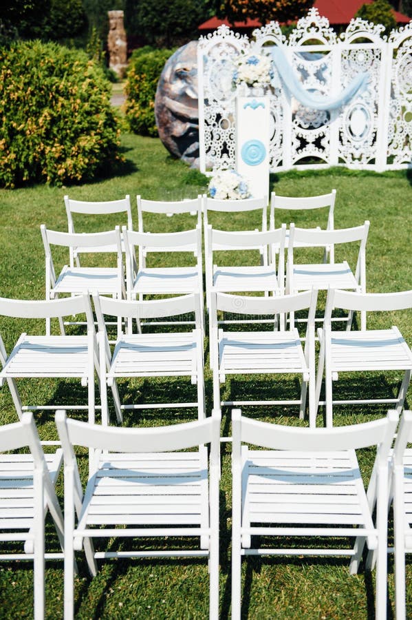 Rows of White Folding Chairs on Lawn before a Wedding Ceremony in