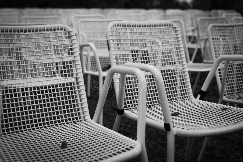 Rows of White Metal Garden Chairs in Front of an Outdoor Stage. Stock