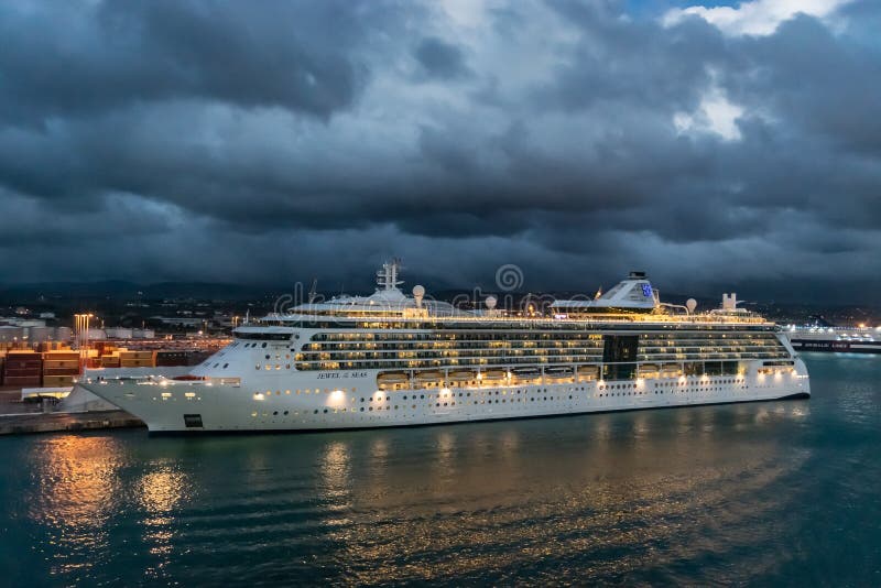 Royal Caribbean kryssningslinjejuvel av havskryssningskeppet som anslutas i porten av Rome på en regnig natt royaltyfria bilder Royal Caribbean kryssningslinjejuvel av havskryssningskeppet som anslutas i porten av Rome på en regnig natt royaltyfria bilder