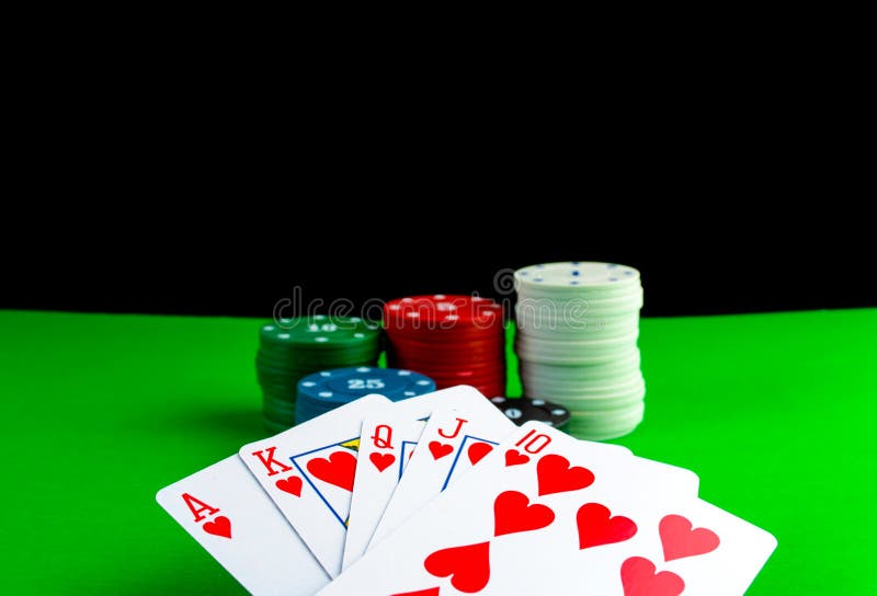 Royal Flush Cards and Poker Chips in Stacks on a Green Table Stock