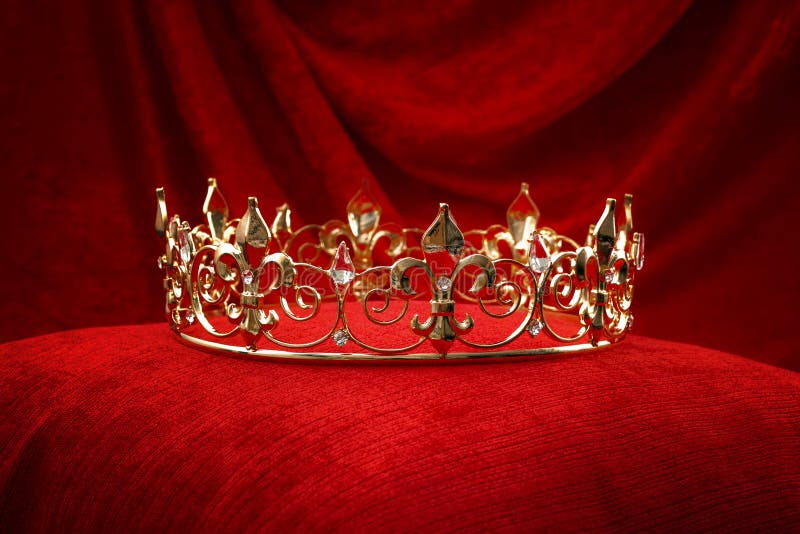 Royalty, monarch coronation or leadership conceptual idea with king gold crown with jewels on red velvet pillow