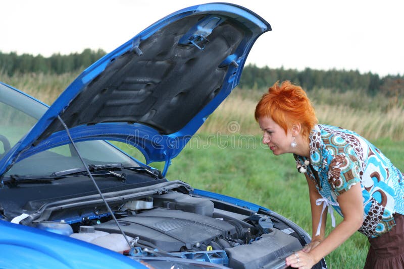 Young red-haired woman with her broken car. The girl have a big problem. Young red-haired woman with her broken car. The girl have a big problem
