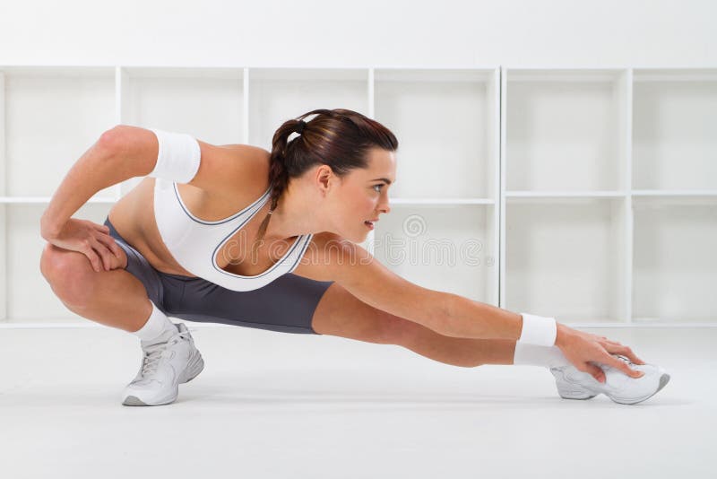 A pretty workout woman stretching her leg muscles before working out. A pretty workout woman stretching her leg muscles before working out