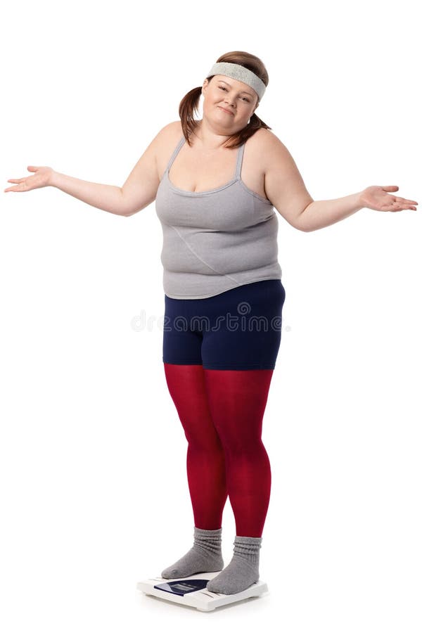 Fat woman standing on scale disappointed with opened arms, wearing sportswear. Fat woman standing on scale disappointed with opened arms, wearing sportswear.