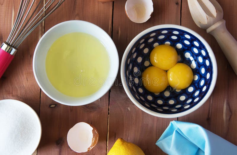 Rozdzielenie yolk jajko w małym pucharze i przygotowanie dla trzepać i jajeczni biel i yolks zdjęcie royalty free Rozdzielenie yolk jajko w małym pucharze i przygotowanie dla trzepać i jajeczni biel i yolks zdjęcie royalty free