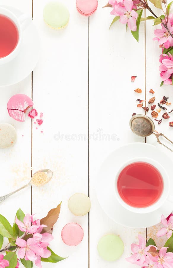 Roze fruitige thee en pastelkleur Franse macaronscakes op wit