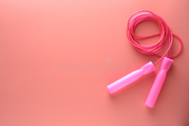 Pink jump rope or skipping rope isolated on pink background. Sports, fitness, cardio, healthy workout concept, lose, weight, diet, equipment, exercise, gym, lifestyle, object, cardiovascular, close, up, healthcare, nobody, train, activity, boxing, yoga, feminine, woman, fashion, summer, training, athletic, footwear, flat, lay, top, view, copy, space, female, active, accessories, yellow, athlete, jogging, sporting, track, boxer, dieting. Pink jump rope or skipping rope isolated on pink background. Sports, fitness, cardio, healthy workout concept, lose, weight, diet, equipment, exercise, gym, lifestyle, object, cardiovascular, close, up, healthcare, nobody, train, activity, boxing, yoga, feminine, woman, fashion, summer, training, athletic, footwear, flat, lay, top, view, copy, space, female, active, accessories, yellow, athlete, jogging, sporting, track, boxer, dieting