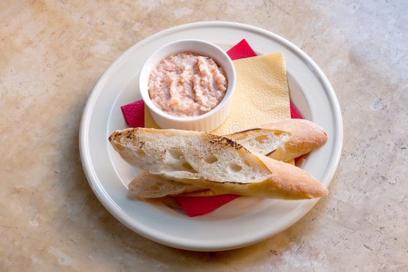 Roze zalmrillette Pastei van gerookte vissen in witte plaat, geroosterd baguettebrood zachte nadrukclose-up stock foto Roze zalmrillette Pastei van gerookte vissen in witte plaat, geroosterd baguettebrood zachte nadrukclose-up stock foto