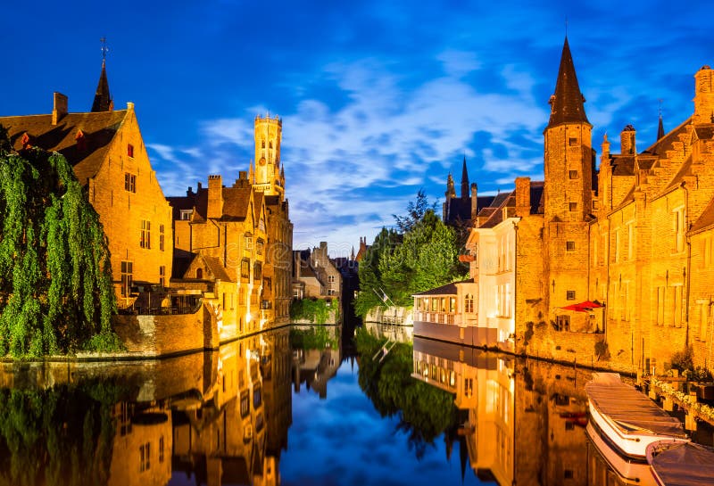 Bruges, Belgium. Image with Rozenhoedkaai in Brugge, Dijver river canal twilight and Belfort (Belfry) tower. Bruges, Belgium. Image with Rozenhoedkaai in Brugge, Dijver river canal twilight and Belfort (Belfry) tower.