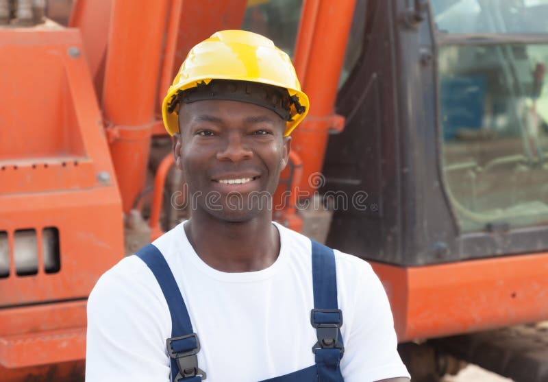 Roześmiany afrykański pracownik budowlany z czerwonym ekskawatorem