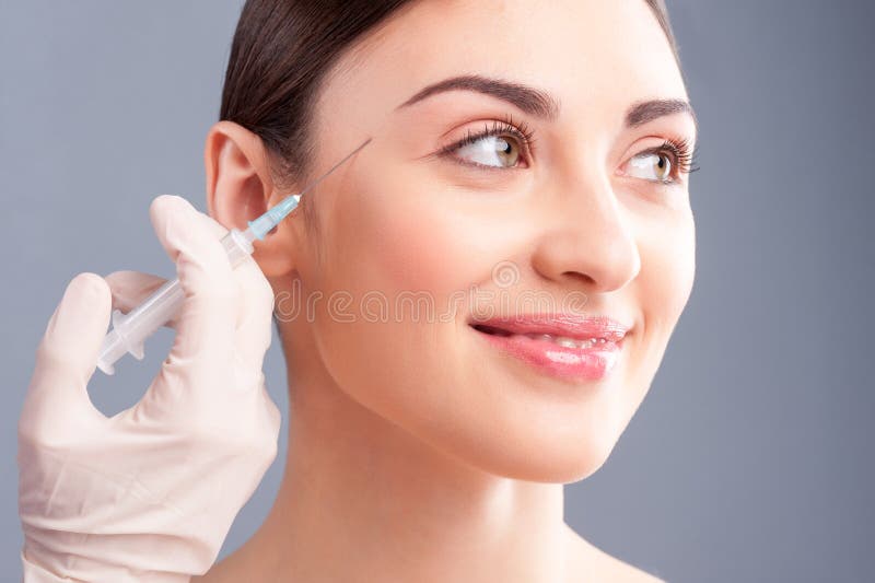Rozochocona brunetki dziewczyna dostaje botox zastrzyka zdjęcie stock Rozochocona brunetki dziewczyna dostaje botox zastrzyka zdjęcie stock