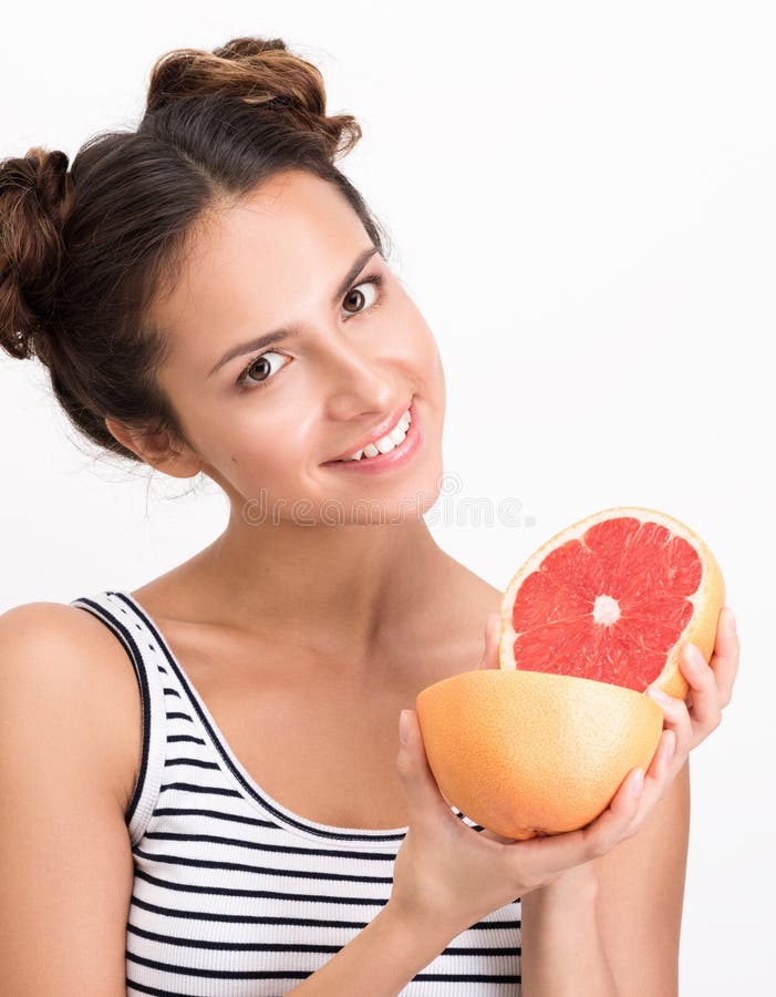 Rozochocona młoda kobieta trzyma grapefruitowego Pionowo zbliżenie portret obraz royalty free Rozochocona młoda kobieta trzyma grapefruitowego Pionowo zbliżenie portret obraz royalty free
