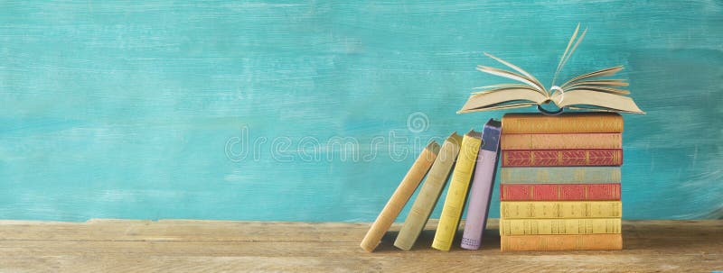 Rozpieczętowana książka na stercie książki, panorama, czytelnicza edukacja, zaświecająca