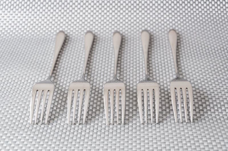 Forks in a row on a silver background. Forks in a row on a silver background