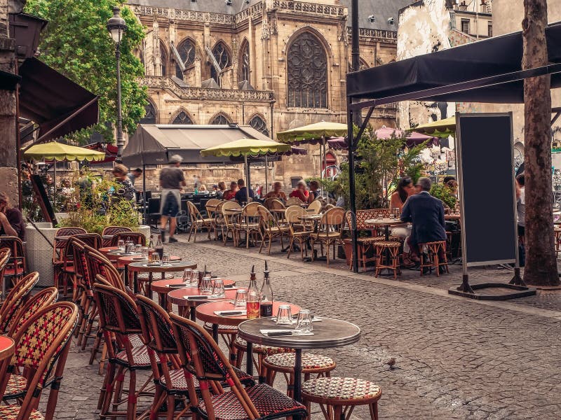 Rua acolhedor com as tabelas do café em Paris