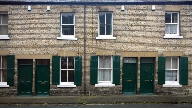 Rua com uma fileira de casas terraced velhas britânicas típicas com portas verdes e de obturadores da janela em durham Inglaterra foto de stock royalty free Rua com uma fileira de casas terraced velhas britânicas típicas com portas verdes e de obturadores da janela em durham Inglaterra foto de stock royalty free