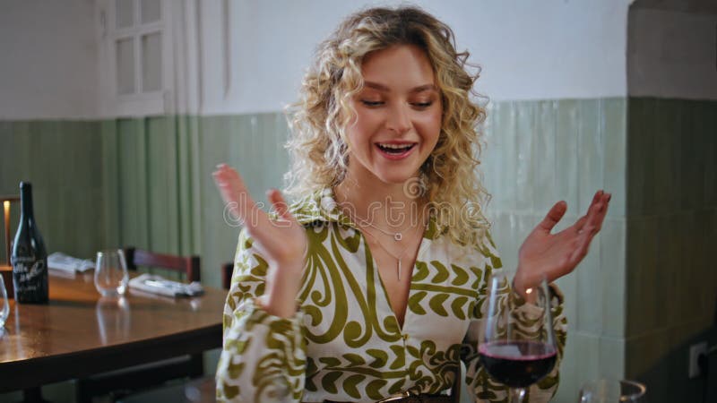Rubia sonriente amigo que habla sosteniendo el vino en el armario del restaurante. feliz almacen de metraje de vídeo