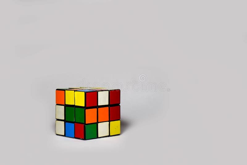 A 3x3 Rubik`s cube placed diagonally on a plain white background. The photograph has empty space for text