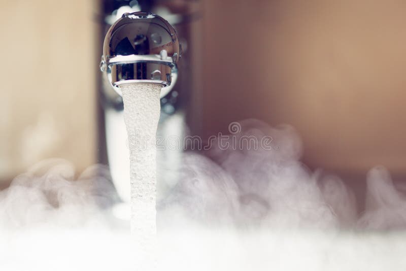 Rubinetto di acqua con il vapore dell'acqua calda