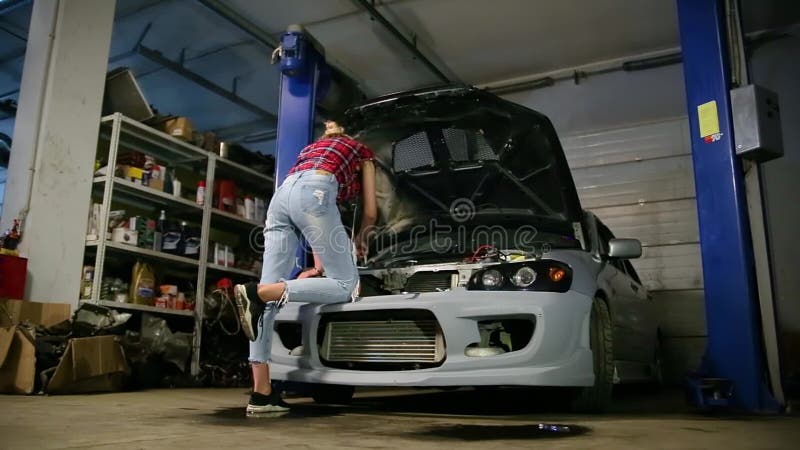 Rubio atractivo en reparaciones de un garaje un coche