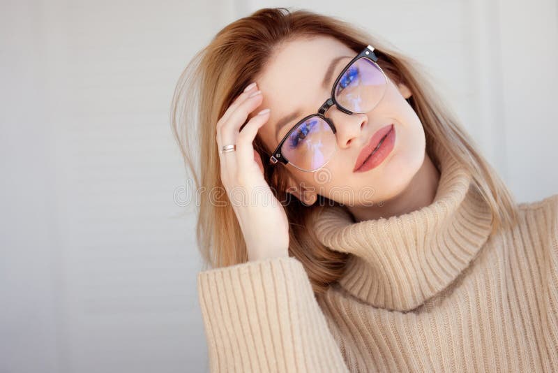 Rubio lindo joven con lentes y un suéter beige Mujer joven de moda elegante imagen de archivo libre de regalías Rubio lindo joven con lentes y un suéter beige Mujer joven de moda elegante imagen de archivo libre de regalías