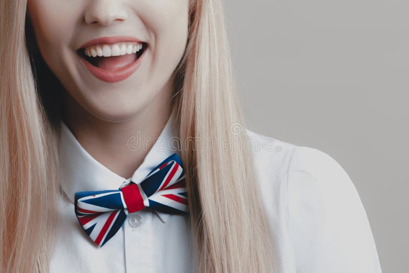 Rubio lindo juguetón joven con la corbata de lazo está riendo fotos de archivo Rubio lindo juguetón joven con la corbata de lazo está riendo fotos de archivo