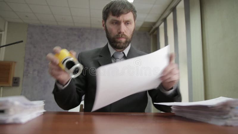 Ruchliwie urzędnik stempluje przybywających dokumenty biznesmen rozprasza dokumenty wokoło