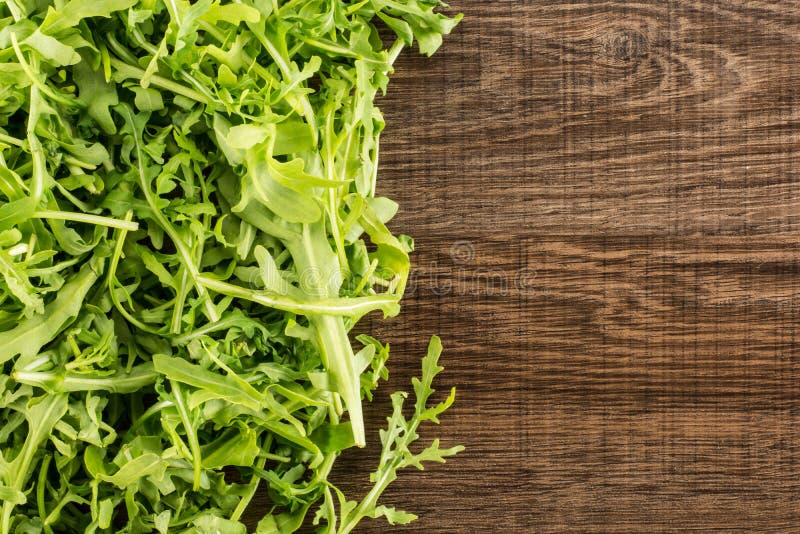 Rucola cruda fresca Rucola su legno marrone fotografia stock Rucola cruda fresca Rucola su legno marrone fotografia stock