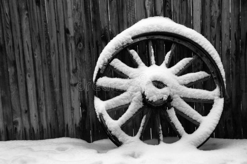 Rueda de carro antigua con nieve fotos de archivo libres de regalías Rueda de carro antigua con nieve fotos de archivo libres de regalías