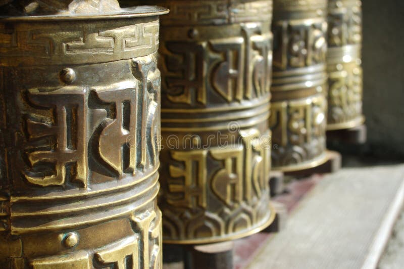 Prayer wheels in front of temple. Prayer wheels in front of temple