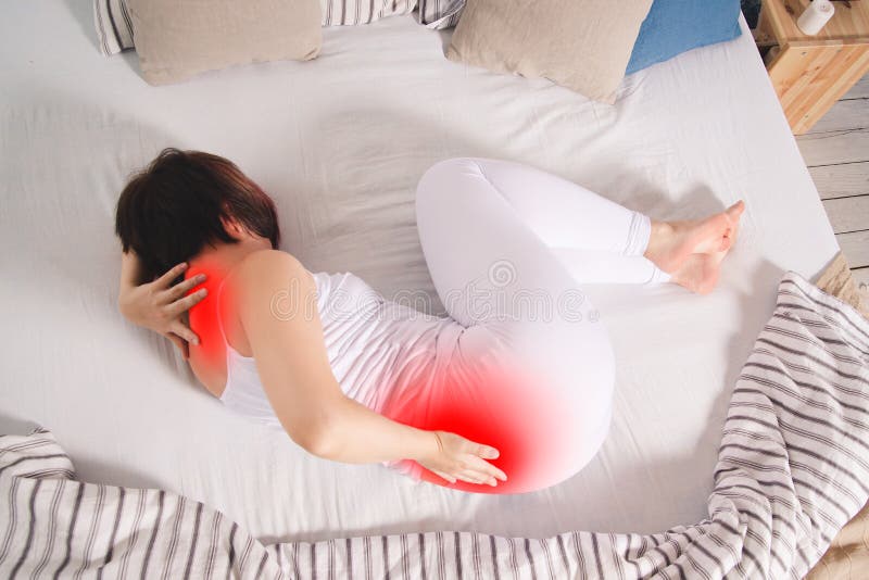 Back pain, kidney inflammation, woman suffering from backache at home, painful area highlighted in red. Back pain, kidney inflammation, woman suffering from backache at home, painful area highlighted in red