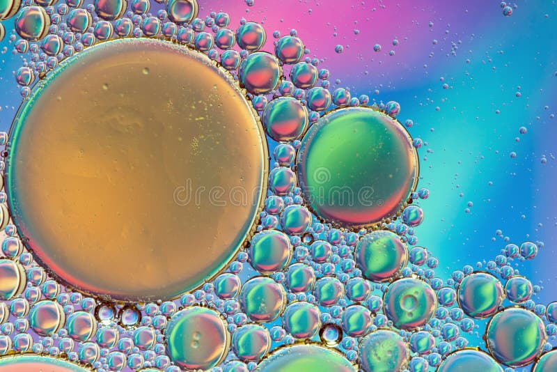 Tranquil, colorful psychedelic abstract in green, blue and gold formed by oil droplets on water. Tranquil, colorful psychedelic abstract in green, blue and gold formed by oil droplets on water