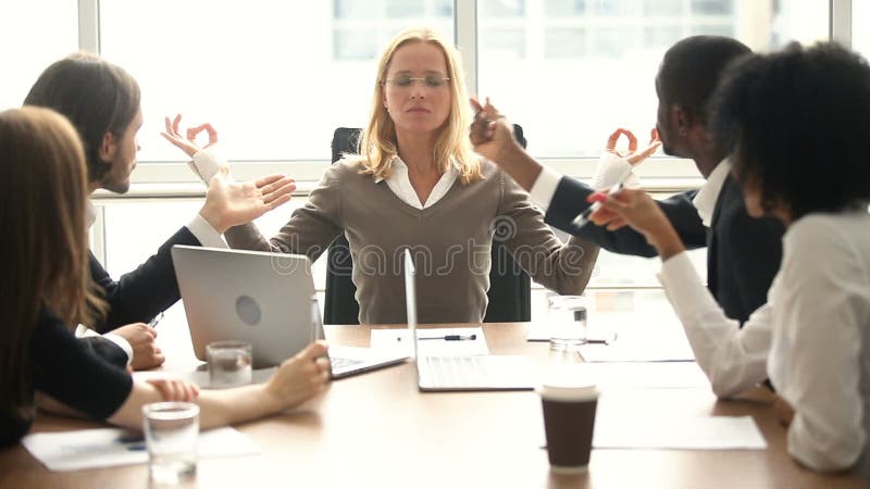 Ruhige Geschäftsfrau, die bei der Sitzung mit gemischtrassigen Kollegen, kein Druck meditiert