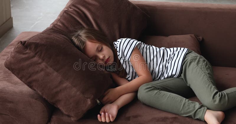 Ruhige kleine, süße kleine Mädchen schlafend auf einem bequemen Sofa.