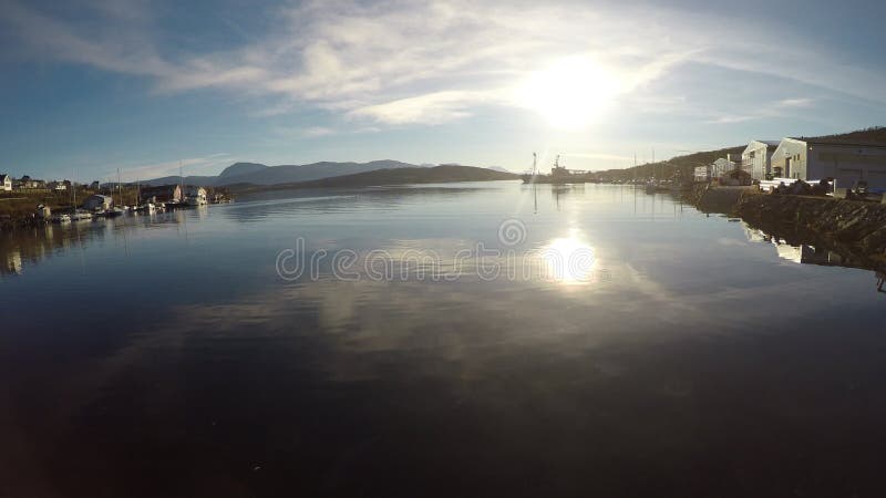 Ruhiges Fjordwasser mit Reflexion des hellen Sonnenscheins mit divererse Gebäuden auf der Walinsel