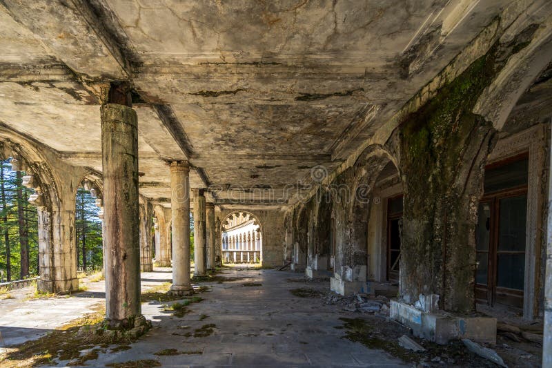 Ruined gallery with arches and weathered columns showcasing historical elegance surrounded by nature. Timeless scene of