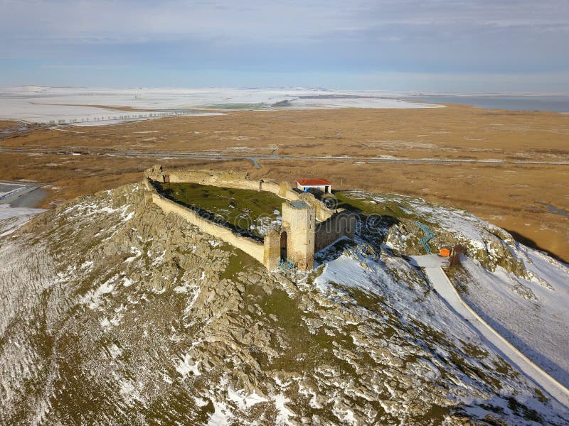 The ruins of medieval fortress Enisala in winter aerial view, located on a limestone hill in Dobrogea - Romania