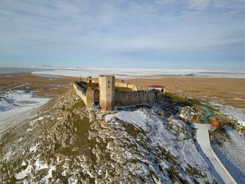 The ruins of medieval fortress Enisala in winter aerial view, located on a limestone hill in Dobrogea - Romania