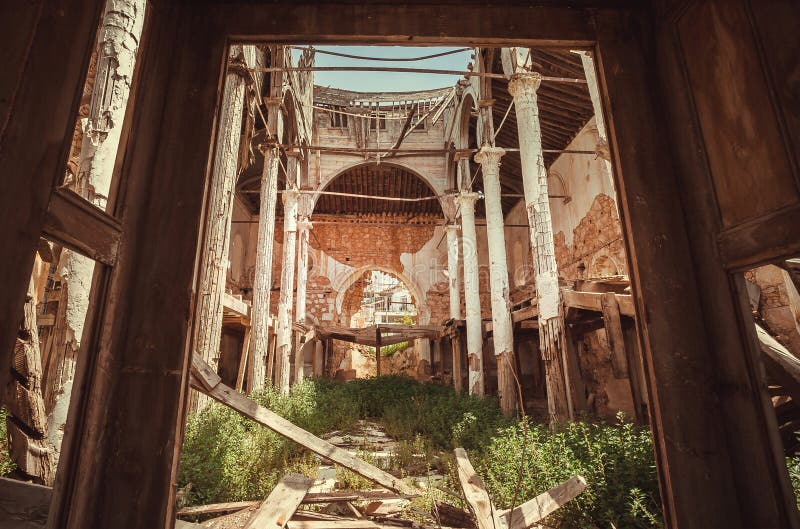 Ruins of old abandoned church with brick walls. Large ruined building with arch and ceiling